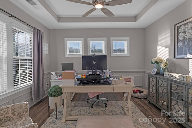 office space with a raised ceiling, ceiling fan, and dark hardwood / wood-style floors