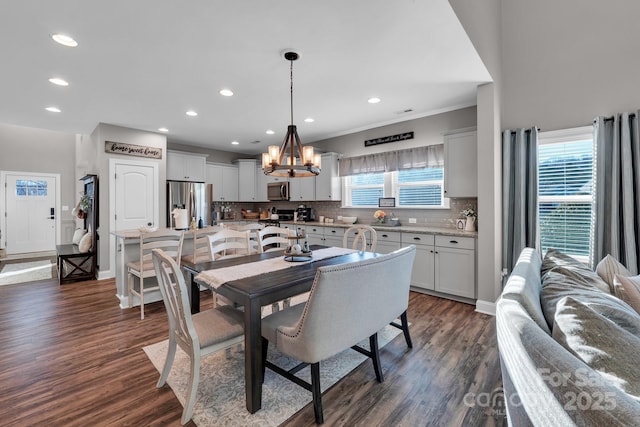 dining space featuring dark wood-type flooring, a chandelier, and a healthy amount of sunlight