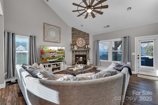 living room featuring high vaulted ceiling, a fireplace, ceiling fan, and dark wood-type flooring