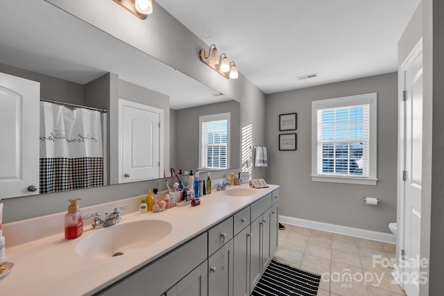 bathroom featuring toilet, vanity, tile patterned floors, and walk in shower