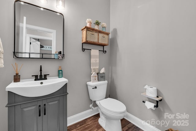 bathroom with hardwood / wood-style flooring, vanity, and toilet