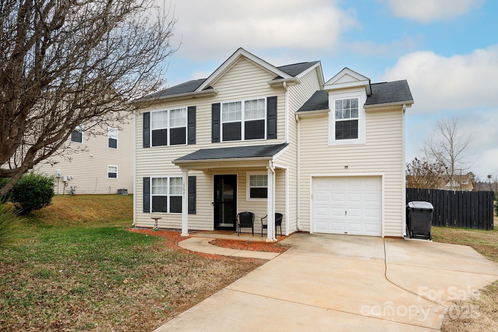 view of property with a garage and a front lawn