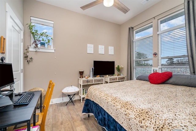 bedroom with baseboards, ceiling fan, visible vents, and light wood-style floors