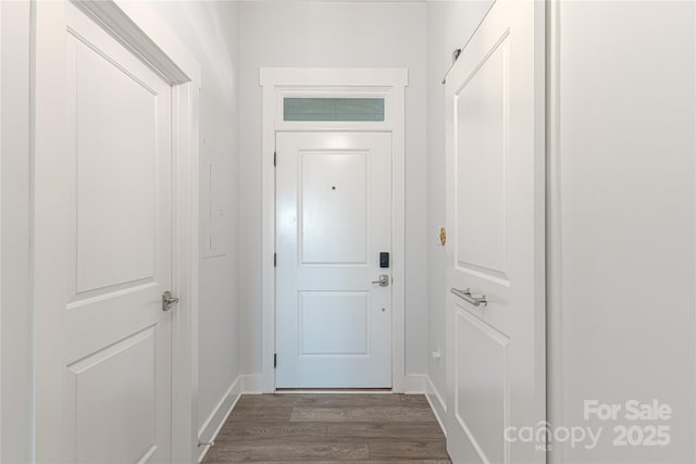 doorway featuring dark wood finished floors and baseboards