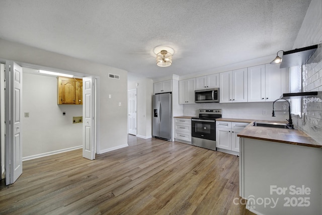 438 Stoneycreek Ln, Rock Hill, SC 29730 - kitchen featuring white cabinetry, sink, stainless steel appliances, and light hardwood / wood-style flooring