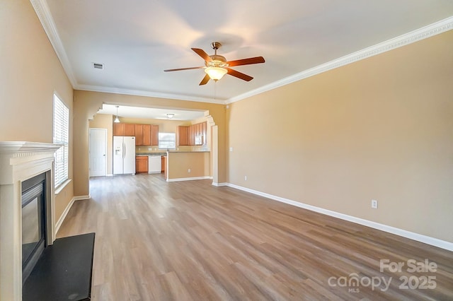 unfurnished living room with light hardwood / wood-style flooring, ceiling fan, and ornamental molding