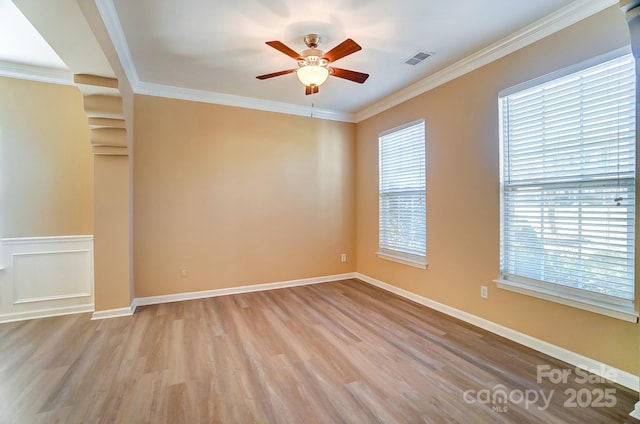 unfurnished room with ceiling fan, light wood-type flooring, and ornamental molding