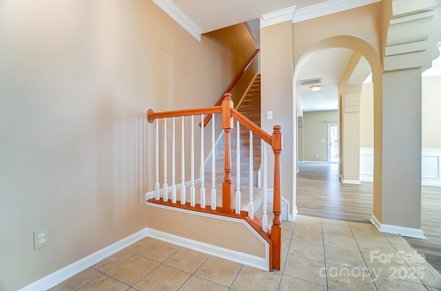 staircase featuring tile patterned floors and ornamental molding