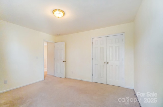 unfurnished bedroom featuring light colored carpet and a closet