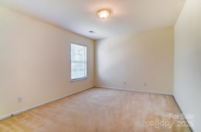 spare room featuring light carpet