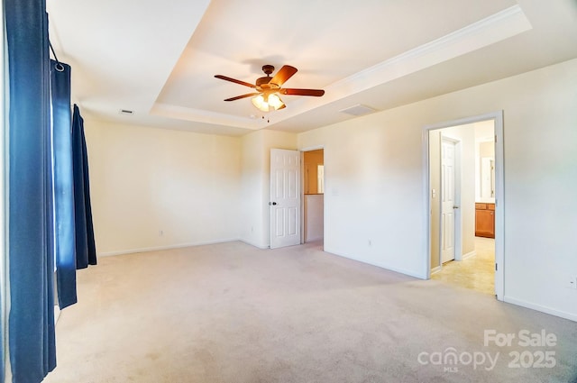 spare room with light carpet, a tray ceiling, ceiling fan, and crown molding