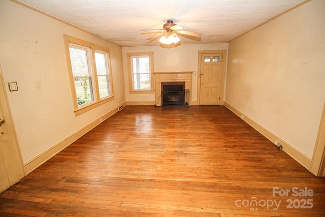 unfurnished living room with hardwood / wood-style flooring, ceiling fan, and ornamental molding