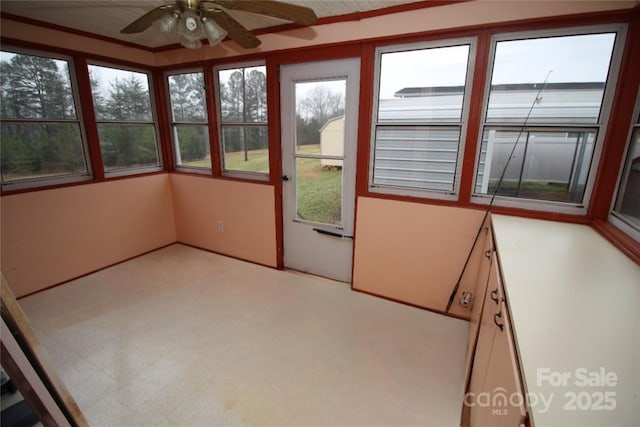 unfurnished sunroom with ceiling fan