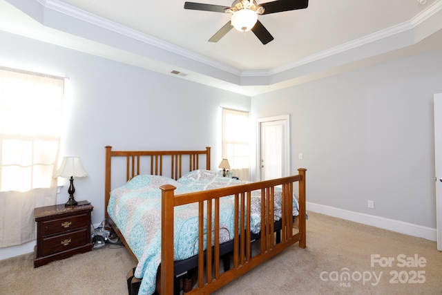 carpeted bedroom featuring a raised ceiling, ceiling fan, and crown molding