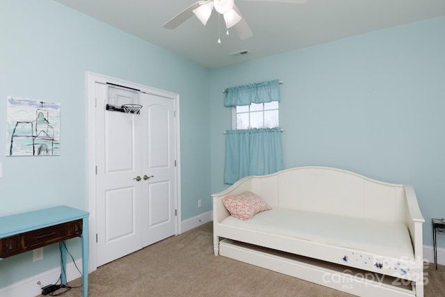 carpeted bedroom with ceiling fan and a closet