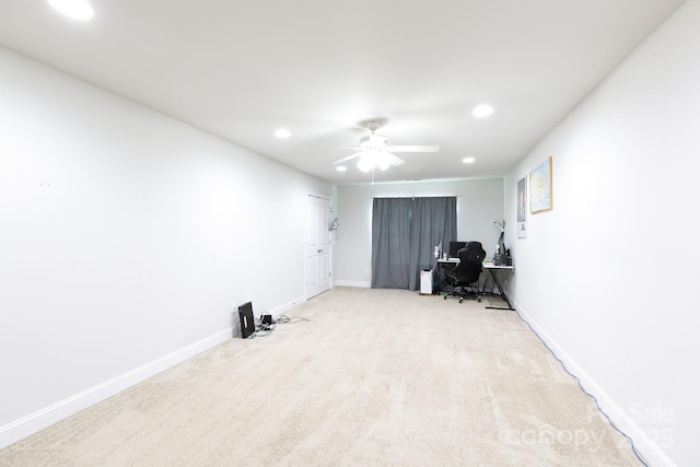 unfurnished office with ceiling fan and light carpet