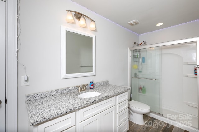 bathroom featuring vanity, toilet, and walk in shower