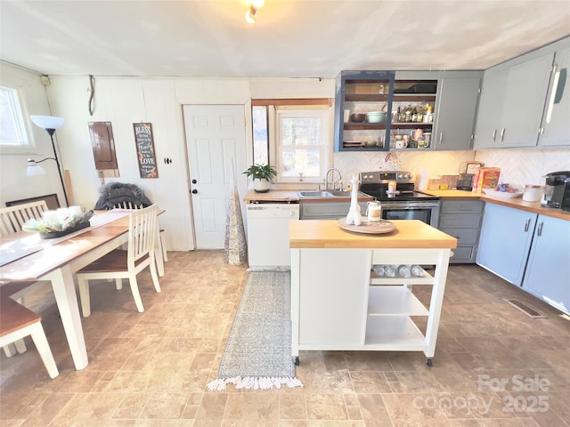 kitchen with dishwasher, sink, butcher block counters, gray cabinetry, and stainless steel electric range