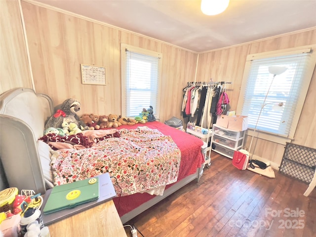 bedroom featuring wooden walls and dark hardwood / wood-style floors