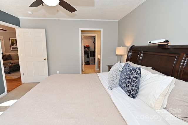 bedroom featuring a walk in closet, carpet, ceiling fan, crown molding, and a closet