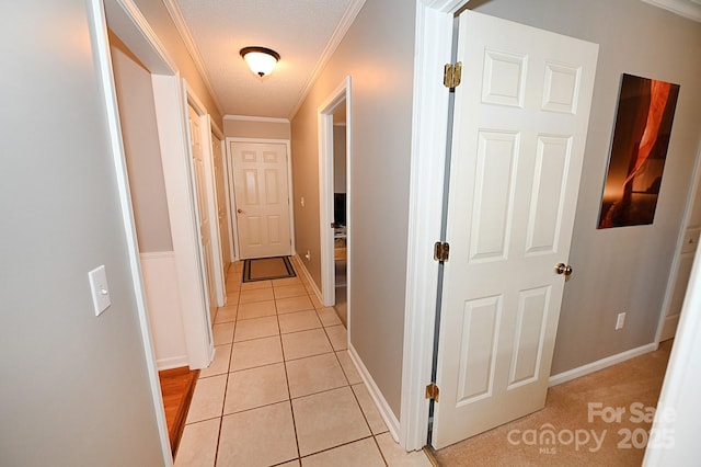 hallway featuring ornamental molding and light tile patterned floors