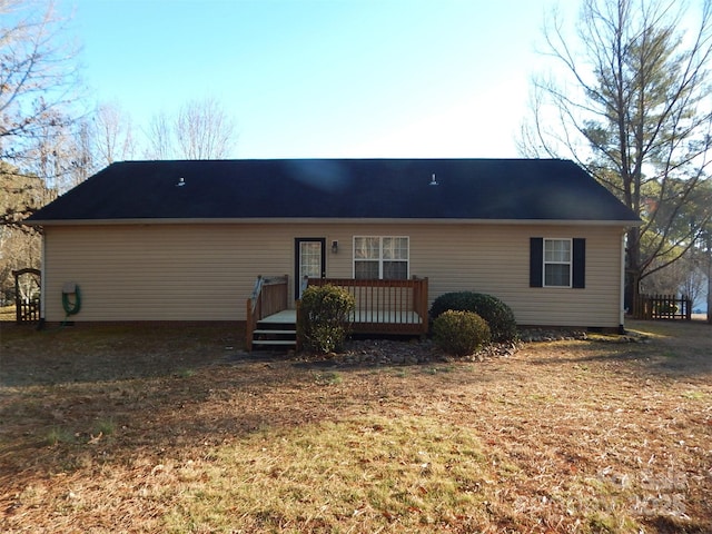 rear view of house featuring a yard and a deck