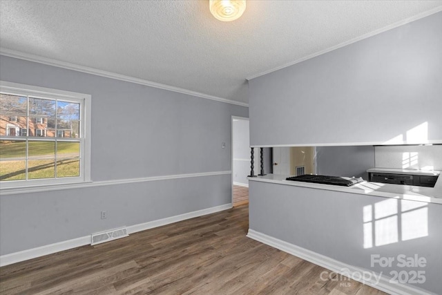 kitchen featuring dark hardwood / wood-style floors, crown molding, and a textured ceiling