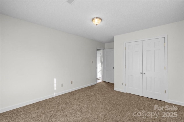 unfurnished bedroom with carpet, a textured ceiling, and a closet