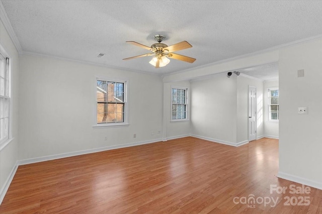 empty room featuring ornamental molding, a textured ceiling, and light hardwood / wood-style flooring