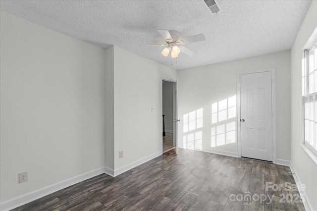 unfurnished room featuring a textured ceiling, a wealth of natural light, and ceiling fan