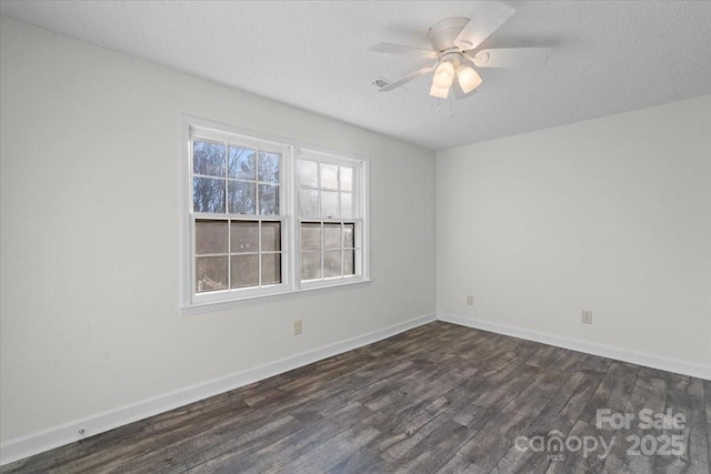 spare room with dark hardwood / wood-style floors, ceiling fan, and a textured ceiling