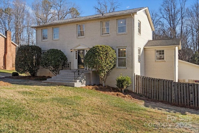 colonial house featuring a front lawn