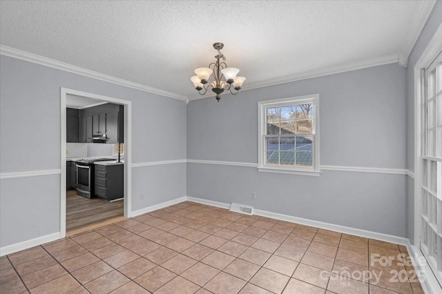 tiled empty room with a healthy amount of sunlight, crown molding, and an inviting chandelier