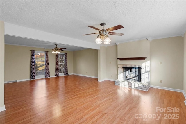 unfurnished living room featuring a fireplace, a textured ceiling, and light hardwood / wood-style flooring