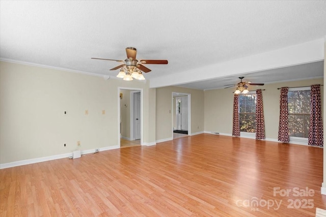 empty room featuring crown molding, a textured ceiling, and light wood-type flooring