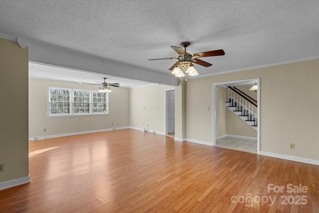 spare room with crown molding, ceiling fan, a textured ceiling, and light wood-type flooring