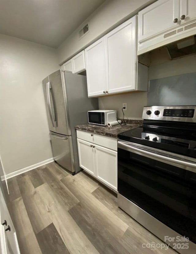 kitchen with stainless steel appliances, white cabinetry, and light wood-type flooring