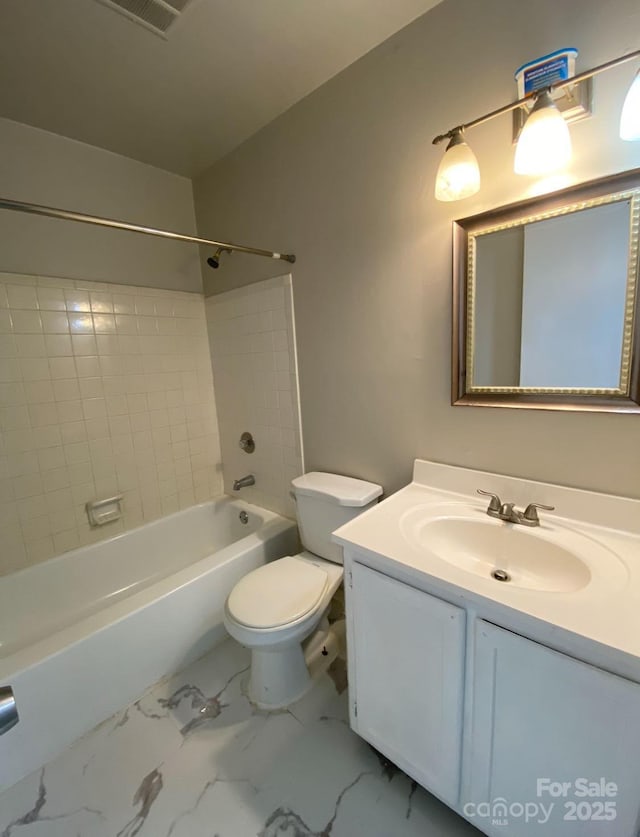 full bathroom featuring tiled shower / bath, vanity, and toilet