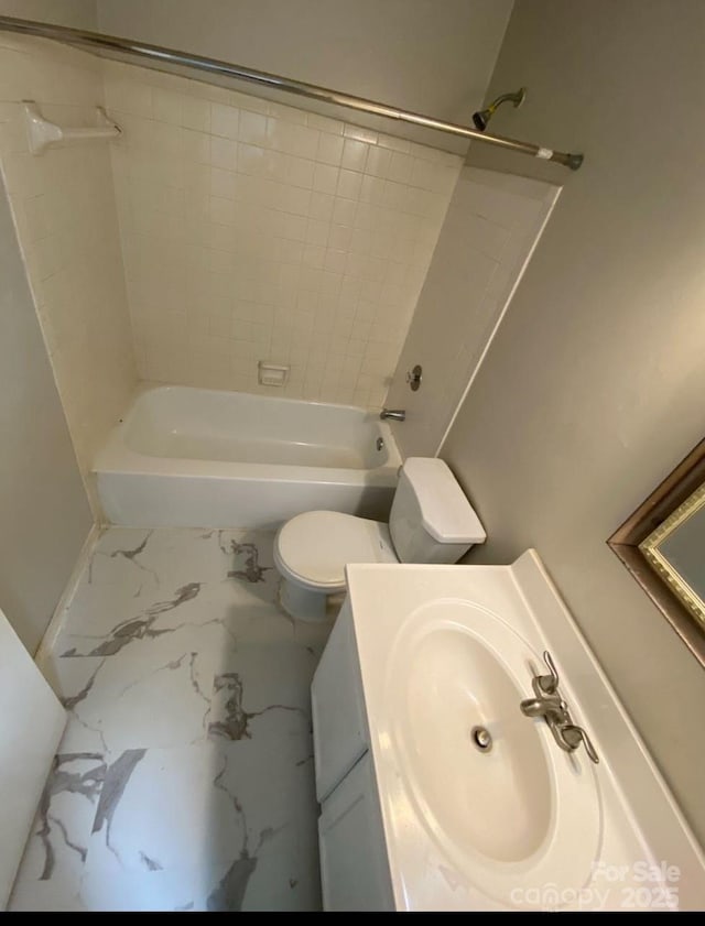 full bathroom featuring tiled shower / bath, vanity, and toilet