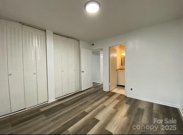 unfurnished bedroom featuring dark hardwood / wood-style flooring and ensuite bathroom