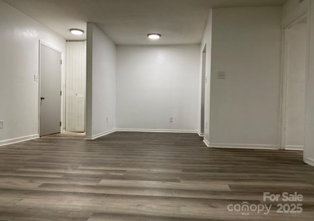 unfurnished room with dark wood-type flooring