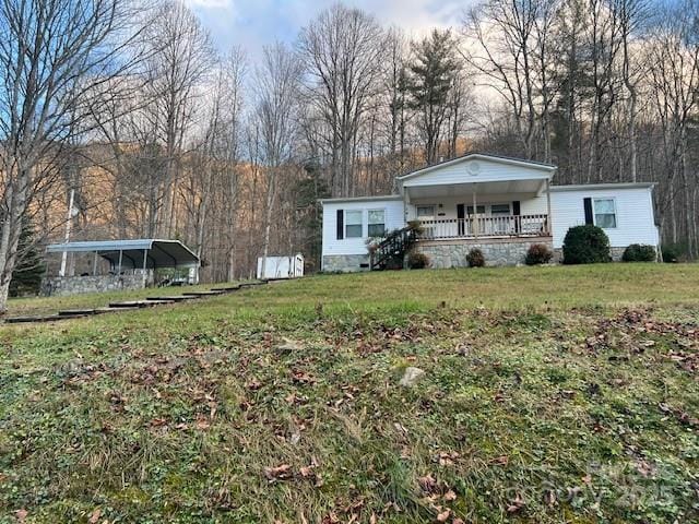 view of front of property featuring a front lawn, a porch, and a carport