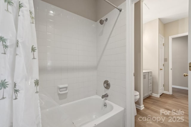 full bathroom with baseboards, toilet, wood finished floors, shower / bath combination with curtain, and vanity