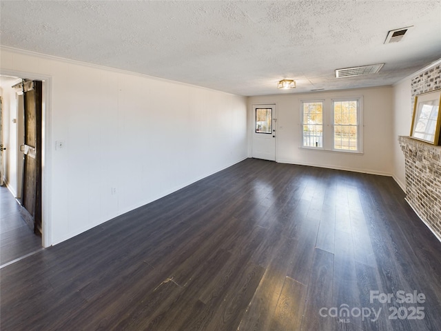 empty room featuring dark hardwood / wood-style flooring and a textured ceiling