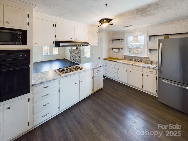 kitchen with white cabinets, sink, a textured ceiling, and appliances with stainless steel finishes