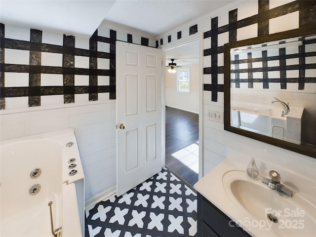 bathroom featuring ceiling fan, a bathtub, vanity, and crown molding