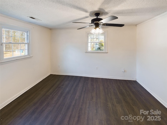 empty room with a textured ceiling, plenty of natural light, and dark wood-type flooring