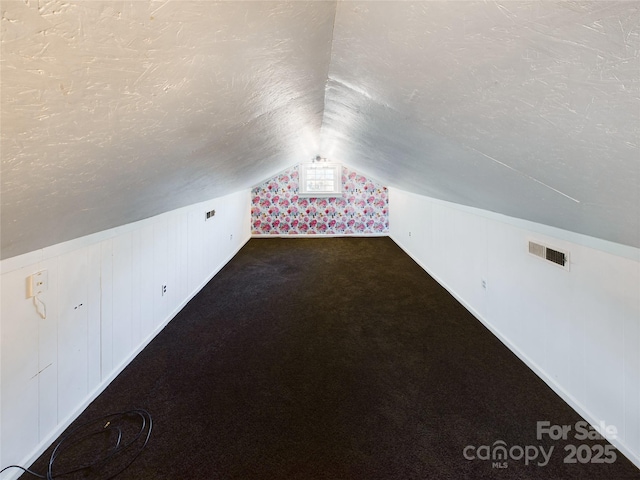 bonus room featuring carpet floors, a textured ceiling, and vaulted ceiling