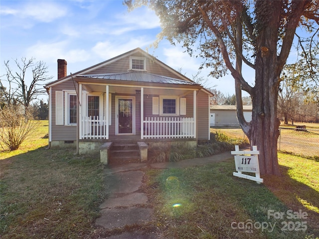 bungalow-style home featuring covered porch and a front lawn