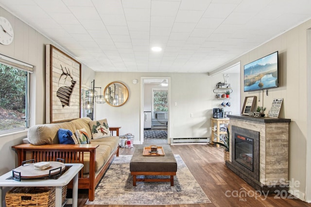 living room with baseboard heating and dark wood-type flooring